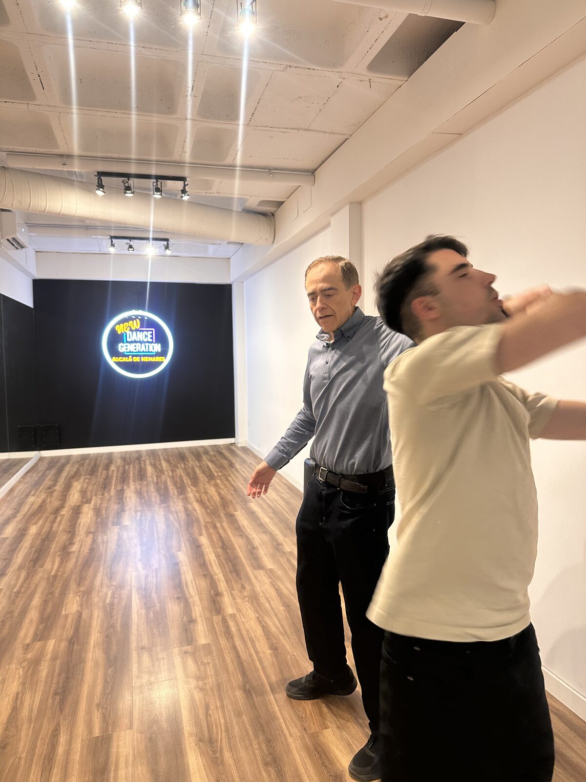 Clase de baile en New Dance Generation (Alcalá de Henares): Pablo Tobares guía el movimiento de brazos de un alumno en la sala